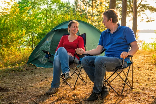 Beautiful young couple sitting next to the tent — Stock Photo, Image