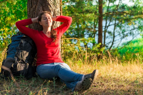 Kesinlikle yorgun backpacker ağaca karşı istirahat — Stok fotoğraf