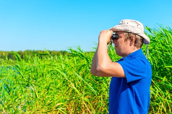 Hunter with binoculars in the reeds — Stock Photo, Image