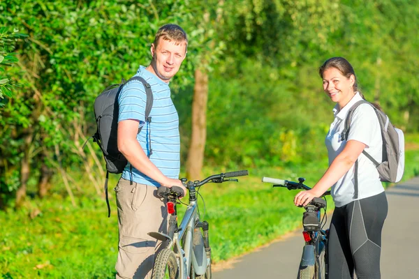 Glada unga människor ridning cyklar — Stockfoto