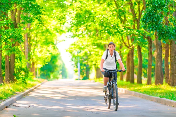 Молода дівчина на велосипеді в парку рано вранці — стокове фото