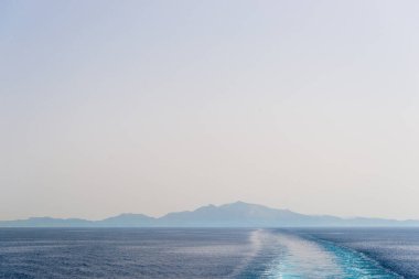 Güneşli bir günde sürat teknesinin kuyruğu suda uyanır.