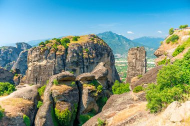 Huge gray rocks Meteors in Greece among green mountain forest