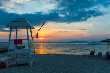 Lifeguard station over the seacoas with sunset on the beach, Evening time