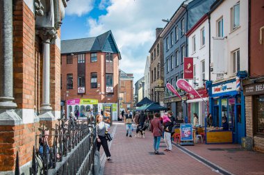 CORK, IRELAND. APRIL 19, 2022. View to the Paul street, people walking around, shops and cafes. Daytime