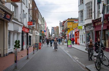 CORK, IRELAND. APRIL 19, 2022. Old city center. Small street with traditional architecture and people walking around. Spring in Europe