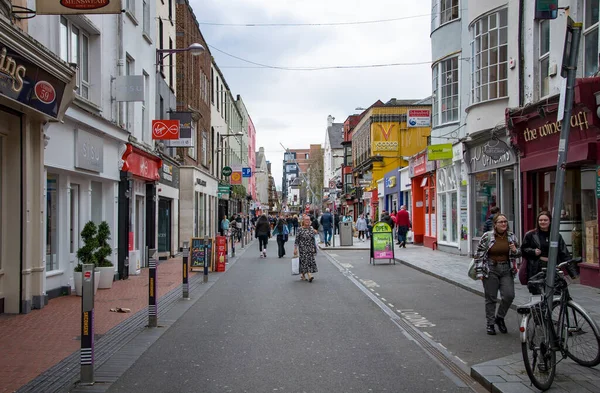 CORK, IRELAND. APRIL 19, 2022. Old city center. Small street with traditional architecture and people walking around. Spring in Europe