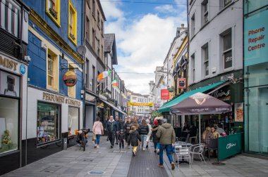 CORK, IRELAND. APRIL 19, 2022. Old city center. Small street with traditional architecture and people walking around. Spring in Europe