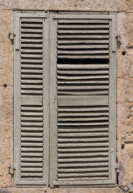 Closed white old shutters in a house in France.