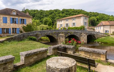 Saint-Jean-de-Cole, Fransa - 12 Haziran 2022: Eski köprüsü olan La Cole nehri ve 'Plus Beaux Village de France' den Saint-Jean-de-Cole köyündeki insanlar.