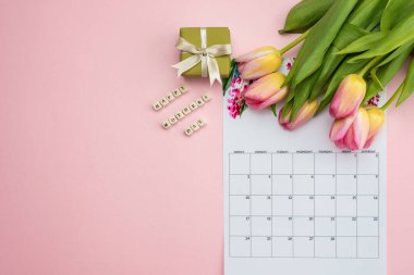 Pembe arka plan takviminde, pembe lalelerde, hediye kutusunda. Anneler Günü 'ne hazırlanıyorum. Boşluğu kopyala, metin için yer