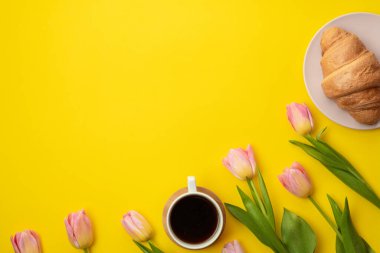 Güzel, pembe laleler, kahve ve kruvasan sarı arka planda. Mesaj için yer. Anneler Günü konsepti.