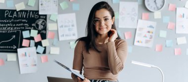 Güzel bir esmer ve çalışan bir geçmişi var. Saçlarını düzleştirir, tatlı tatlı gülümser, kameraya bakar..