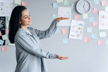 Gri arka planda güzel bir esmer. Genç kadın kopya alanında, metin için yer.