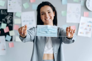 Koruyucu bir maske takan genç ve güzel bir kadın koruyucu bir maske takmak ve takmak istiyor. Nefsi müdafaa kavramı.