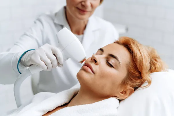 Primer Plano Cara Femenina Recibiendo Masaje Facial Eléctrico Por Esteticista — Foto de Stock