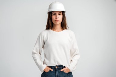 Ciddi yetenekli kadın inşaat işçisi beyaz arka planda tecrit edilmiş görünüyor. Endüstri bakım ve mühendislik kavramı 
