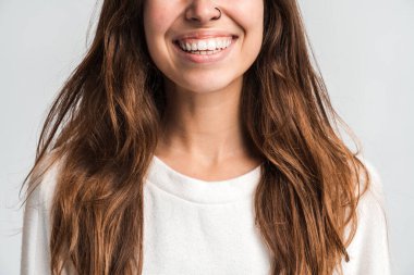 Gülümseyen bir kadının pozitif duyguları ve mutluluğu ifade ederken iyi bir ruh hali içinde olduğu görüşü. Beyaz arka planda izole edilmiş kapalı stüdyo görüntüleri