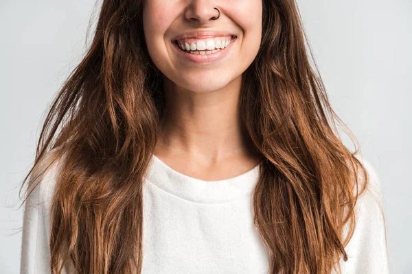 Gülümseyen bir kadının pozitif duyguları ve mutluluğu ifade ederken iyi bir ruh hali içinde olduğu görüşü. Beyaz arka planda izole edilmiş kapalı stüdyo görüntüleri