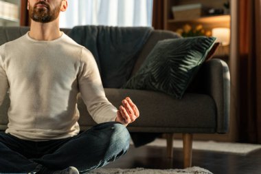 Fitness, meditation and healthy lifestyle concept. Caucasian man meditating in lotus pose at home 