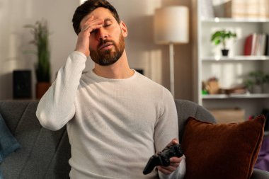 Gamer man with joystick lose in the game. Missed the chance to become a champion in tournament. Young guy playing video game online at home 