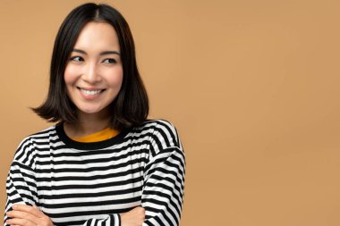 Güzel görünümlü güzel bir kadının yakın plan portresi yeni bir fikir çözümü yaratıyor ve bej renkli arka planda izole edilmiş fotokopi alanını hayal ediyor.