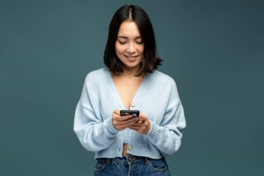 Sosyal ağda komik mesajlar yazarken ya da okurken, mutlu esmer kadın cep telefonu kullanıyor ve neşeyle gülümsüyor. Çevrimiçi iletişim kavramı