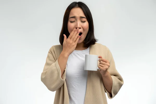 国内服を着たアジア人女性が朝 コーヒーを片手にあくびをしている 毎日の朝のルーチンと新しい日の概念の開始 — ストック写真