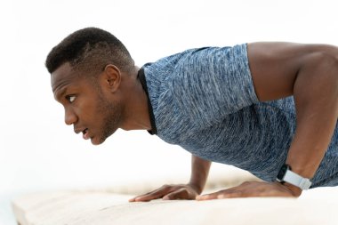 Spor ve sağlıklı yaşam tarzı. Okyanus sahilinde şınav çeken çok ırklı genç adamın görüntüsü. Stok fotoğrafı 