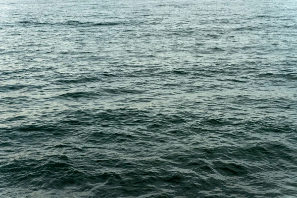 Derin mavi okyanustaki küçük deniz dalgalarının kırpılmış görüntüsü. Doğa ve su kavramı. Stok fotoğrafı 