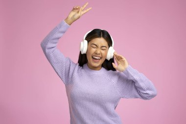 Beyaz denge ya da kredi kartı tutan ve pembe duvar arkasında izole edilmiş poz veren pozitif rüya gören güzel bir kadın resmi. Para kavramı 