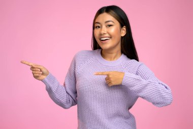 Beyaz denge ya da kredi kartı tutan ve pembe duvar arkasında izole edilmiş poz veren pozitif rüya gören güzel bir kadın resmi. Para kavramı 