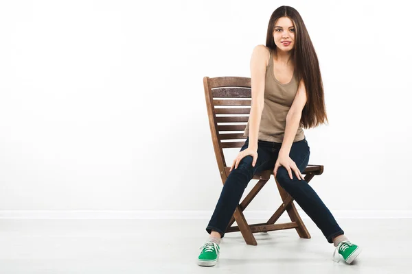 Sandalyede oturan güzel genç bir kadın — Stok fotoğraf