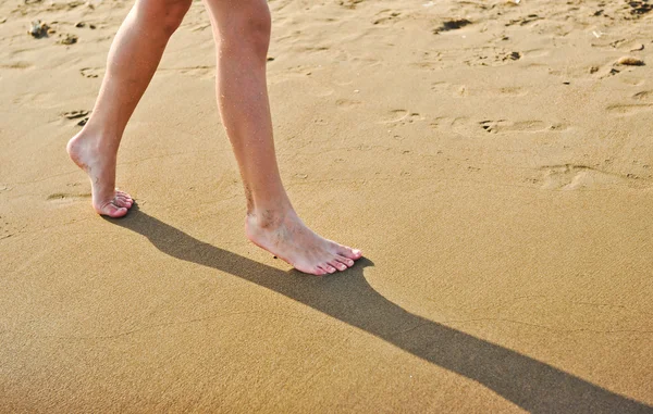 Босоногие ноги девушки на песчаном пляже — стоковое фото
