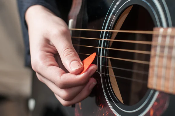 Mano femenina tocando la guitarra acústica. — Foto de Stock