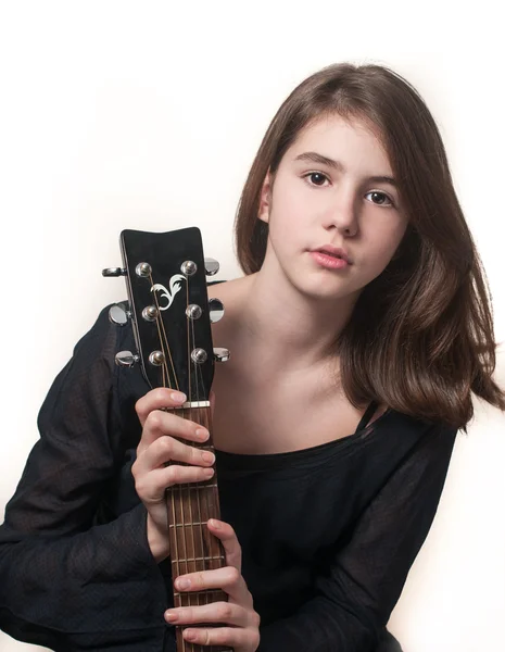 Giovane ragazza bruna adolescente che suona la chitarra acustica isolata sul bianco . — Foto Stock