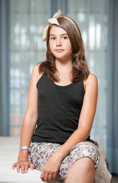 Menina adolescente bonita deitada na cama e olhando para camera.Image de adolescente bonita posando interior de bom humor — Fotografia de Stock