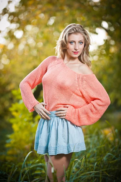 Sexig elegant kvinna med rosa skjorta som sitter på gräset i höst park .young vacker kvinna på hösten park. vacker kvinna med rosa skjorta spendera tid i parken under höstsäsongen . — Stockfoto