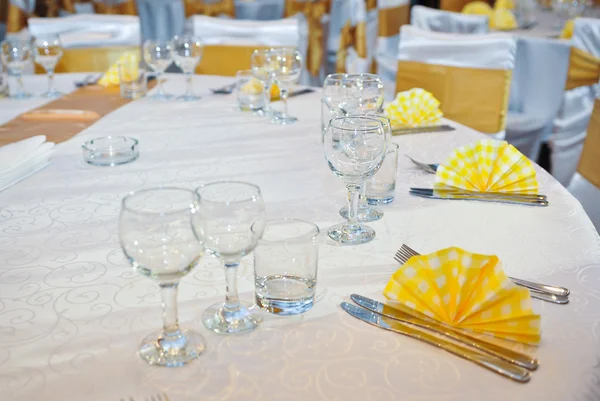 Lepel, vork, schone borden, glazen en een mes vastgebonden feestelijke lint. Ga liggen op tafel — Stockfoto