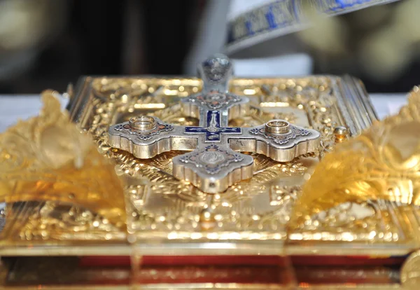 Croix, anneaux et couronnes d'or sur la table de l'église — Photo