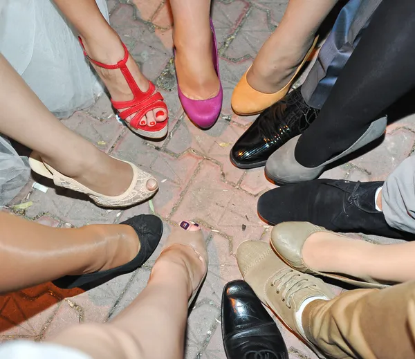 Ноги и обувь, стоящие в кругу в плитке — стоковое фото
