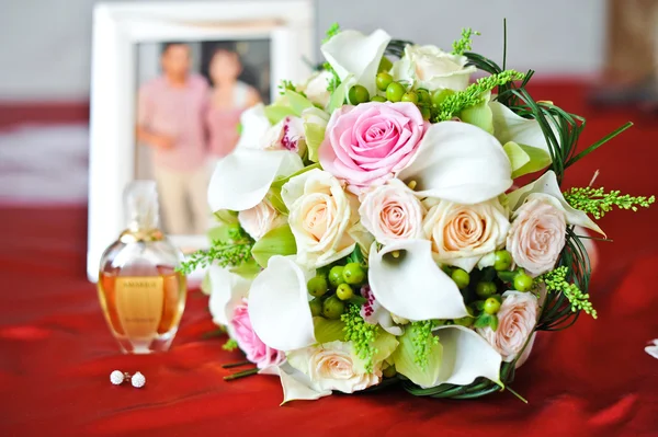 Bouquet, perfume passports and earrings — Stock Photo, Image