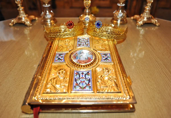 Crosses, rings and crowns of gold on the table in church. — Stock Photo, Image