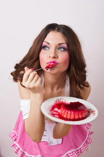 Attractive young satisfied woman eating pudding isolated on white background . — Stock Photo, Image