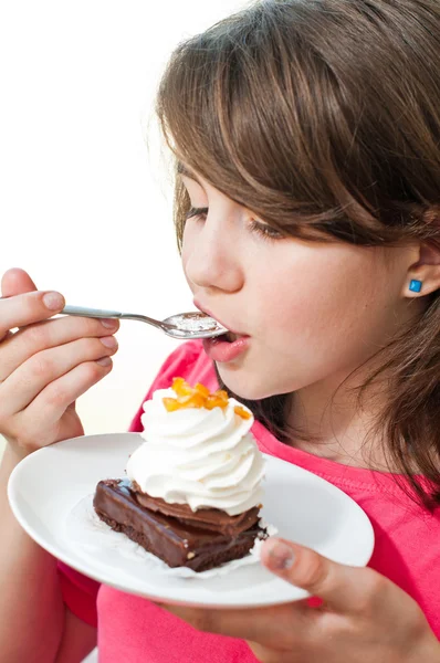 Zábavné teen brunetka jíst dort na bílém pozadí — Stock fotografie