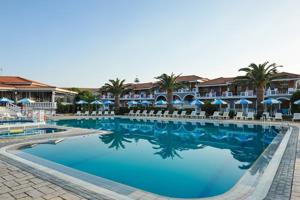 Luxusní bazén v tropické hotel v greece.chaise longue a bazén v hotel.swimming bazénu s palm trees.resort fondem v zakynthos — Stock fotografie