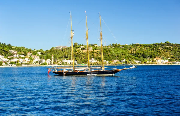 Antica nave alta che naviga su acque blu. Nave alta sotto vela con la riva sullo sfondo. Nave in stile pirata che salpa in alto mare — Foto Stock