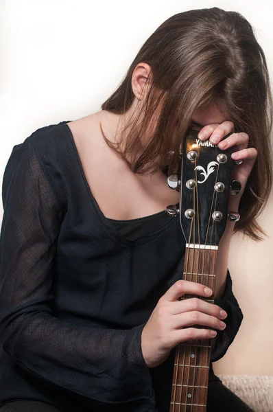 Young brunette teen girl playing acoustic guitar on white — Stock Photo, Image