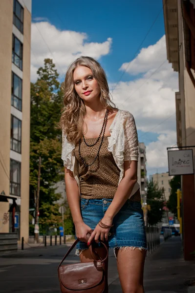 Girl short skirt and bag walking on street.Young European Girl in Urban Setting.sexy woman dressed provocatively and posing on street.Blonde attractive woman with interesting hair walking in the city — Stock Photo, Image