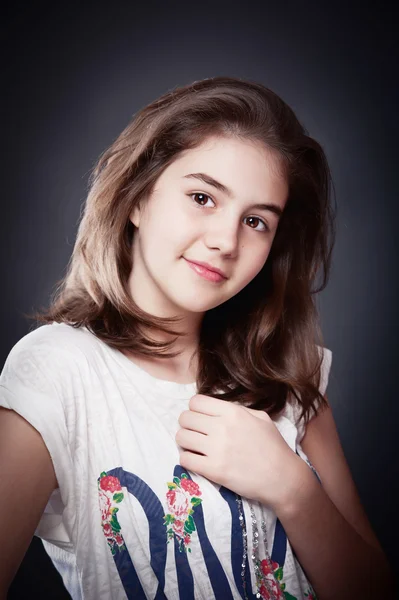 Hermosa chica adolescente con el pelo largo y liso, posando sobre el fondo.Retrato de una hermosa adolescente con largos pelos rizados — Foto de Stock